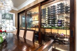 42 - A large dining room wine closet sits beside this home's formal dining area, giving guests an incredible view of the entire wine collection. photo of massive glass wine closet with amazing display