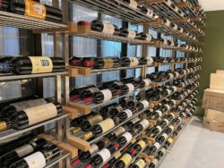 36 - This custom metal racking includes brushed stainless steel posts, white oak supports, and aluminum rods. Metal rod wine racking in modern Orange County residential wine cellar