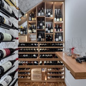 This is a modern wine cellar with complete functionalities, including a dedicated countertop for decanting.