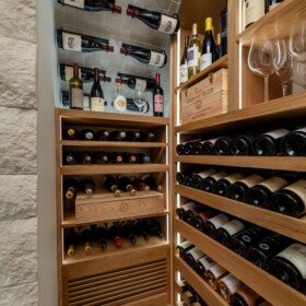 The louvered grill at the bottom of this modern wine cellar hides the split-system cooling unit, so it doesn't disturb the overall aesthetic of the room.