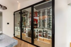 (2) This luxury wine cellar for homeowners makes a sophisticated statement with a high ceiling display and clear glass doors.