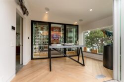 (1) A sleek, modern wine cellar for home interiors featuring framed glass and a diverse wine racking configuration.