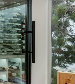 (9) This wine cellar for home features clean lines and a stylish black-framed glass door that blends with any modern interior.